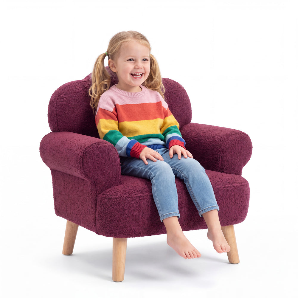 Theo kids armchair in deep rouge bouclé upholstery with a scalloped backrest